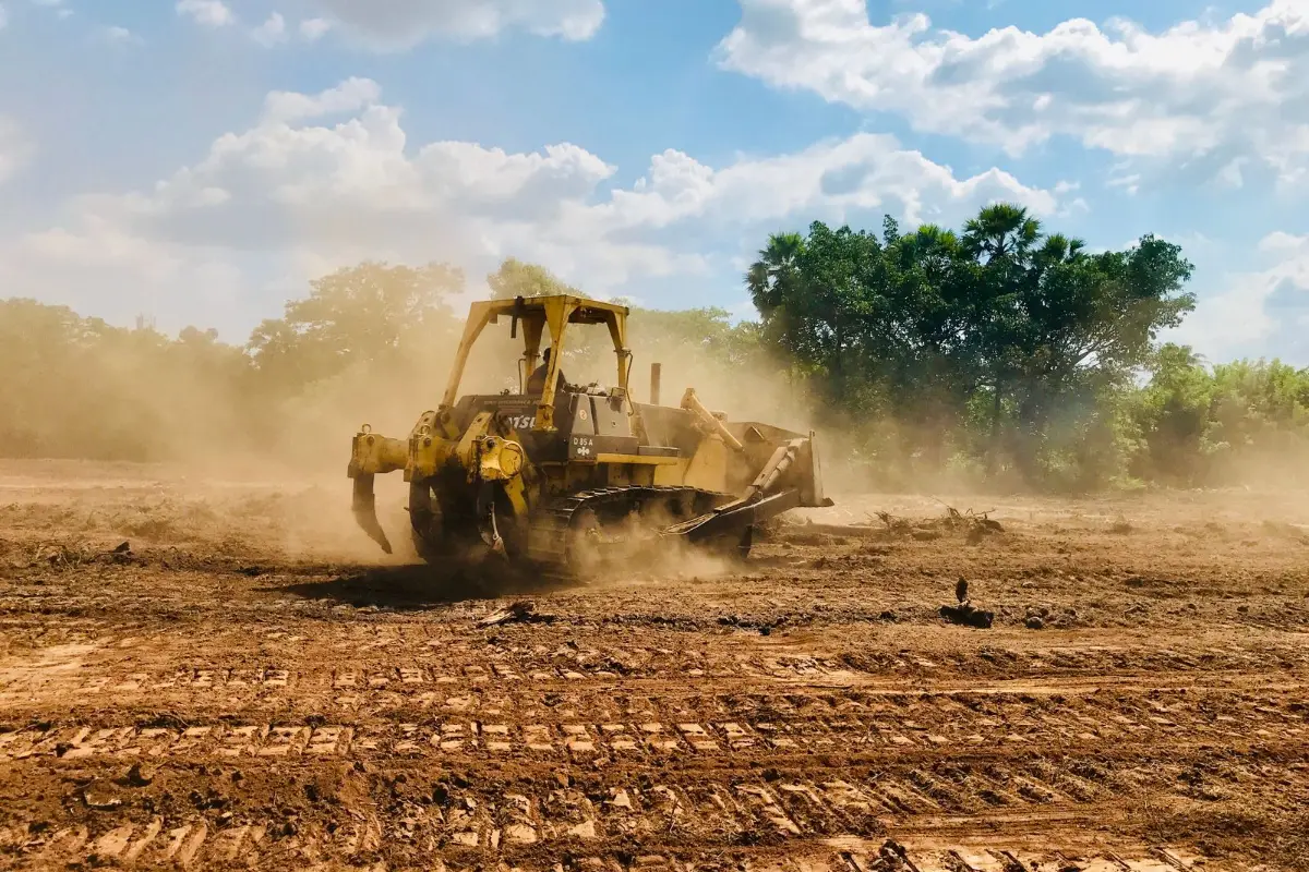A dozer pushing earth across a cleared site